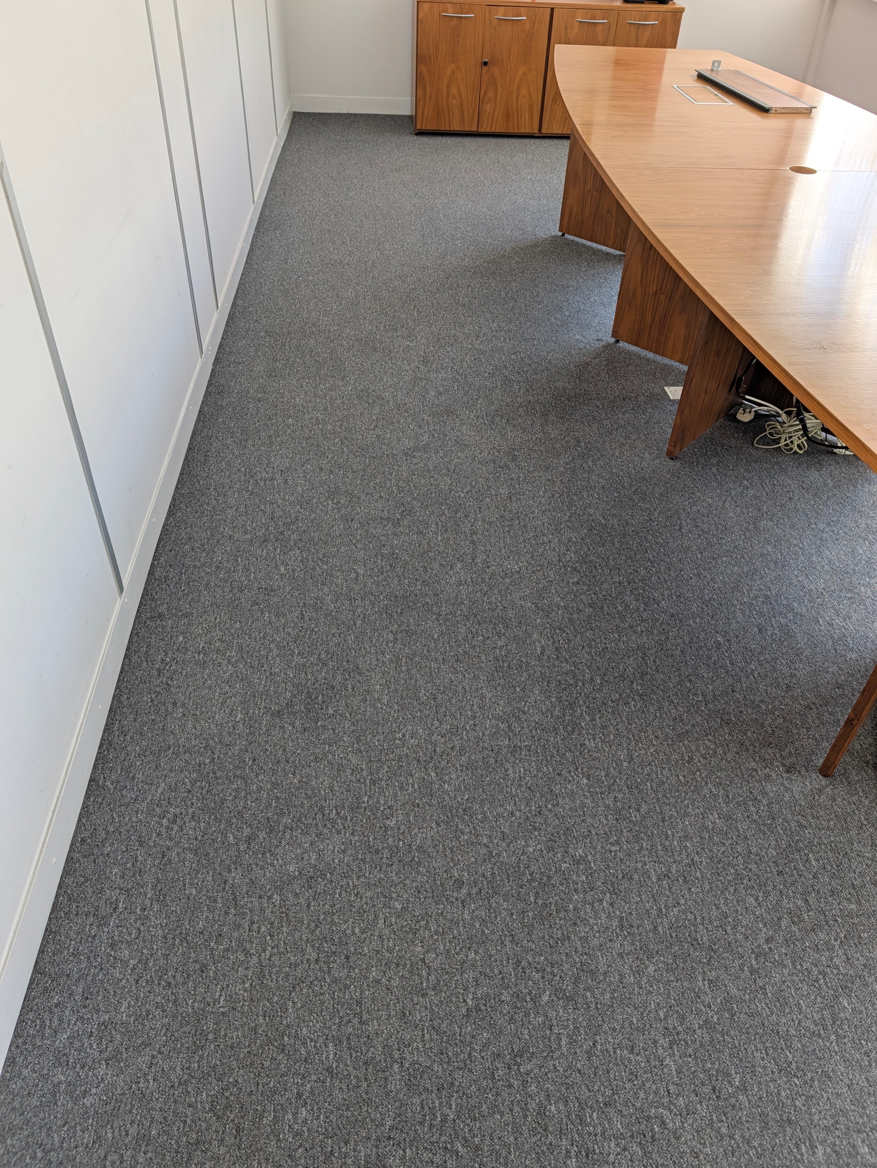 Meeting room carpet before cleaning — visible soiling under conference chairs
